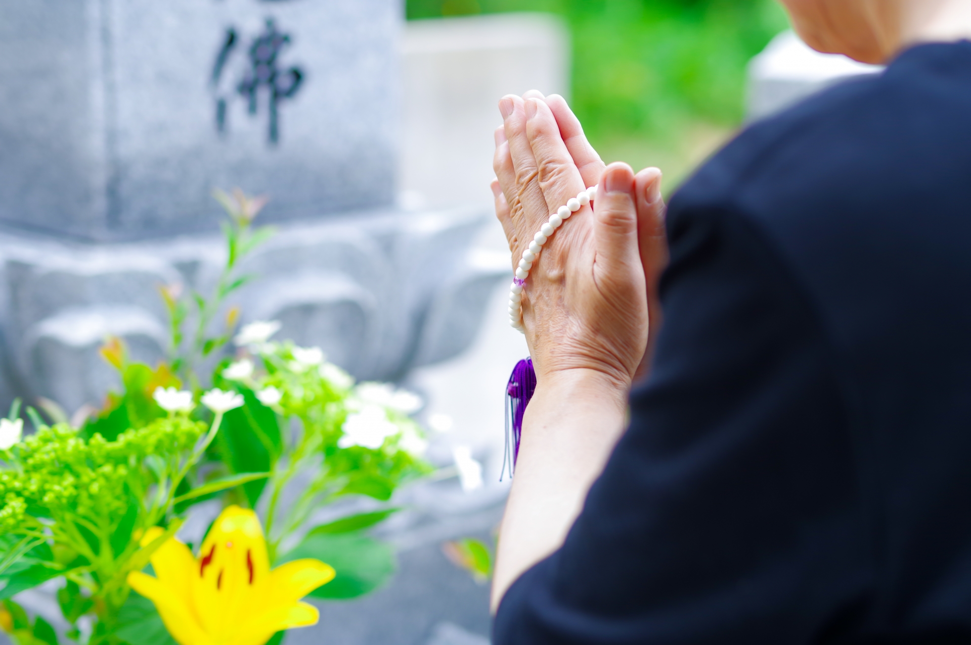 お墓に手を合わせる人