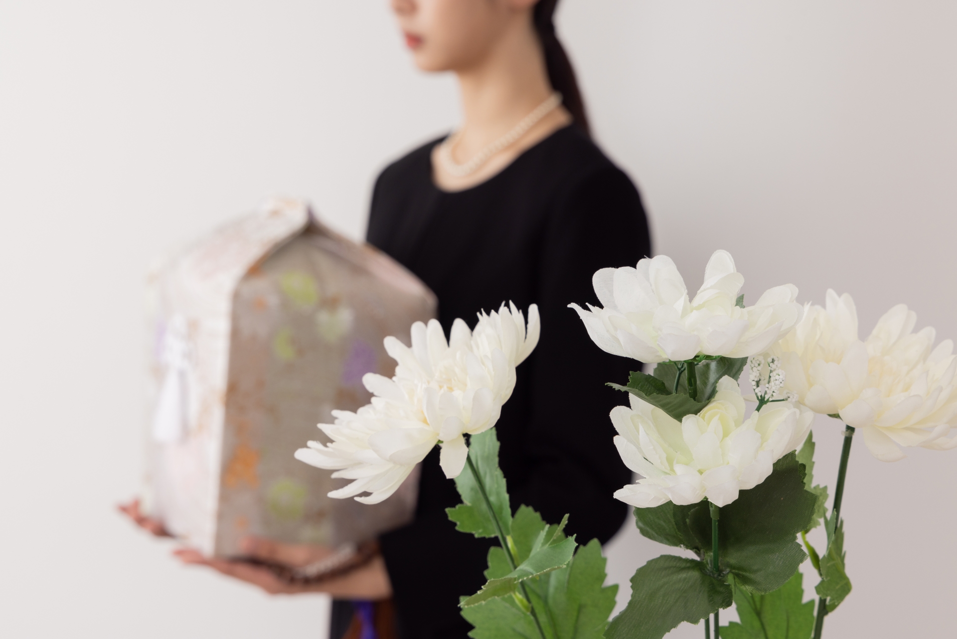 骨壺を移動する女性